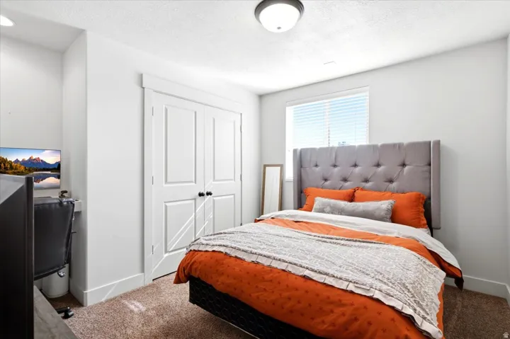 Recessed built-in desk, double closet doors, overhead flush-mount lighting, and large window with blinds