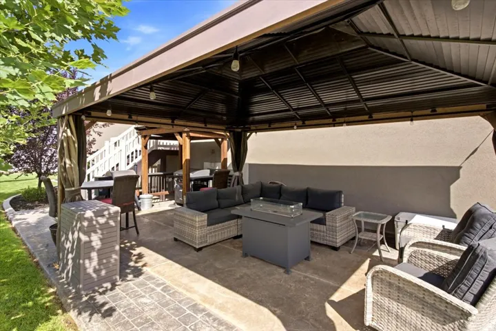 Expansive patio featuring a substantial gazebo, stamped concrete, and integrated lighting