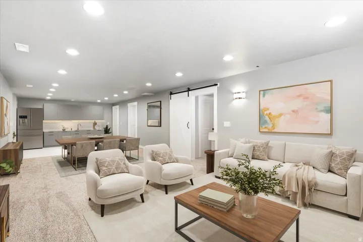 Open-concept living area with recessed lighting, a barn door, and wall sconces