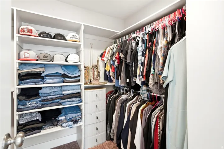 Built-in closet shelving and multiple hanging rods provide ample storage