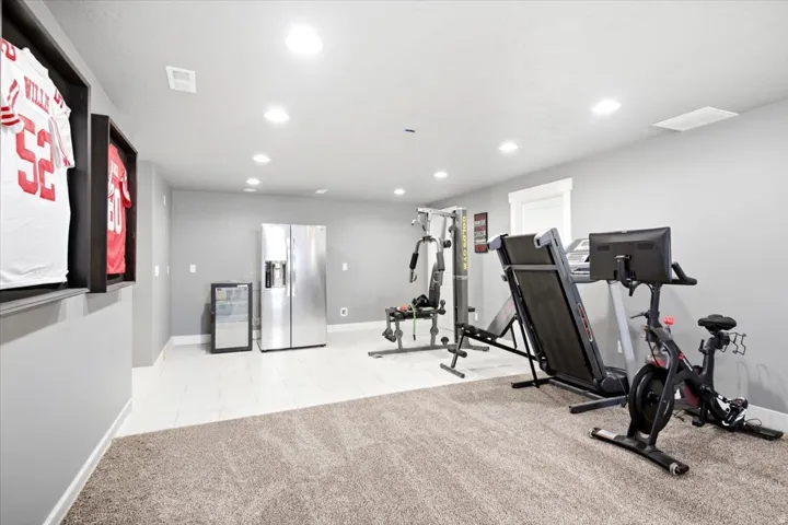 Spacious room featuring recessed lighting, a combination of carpet and tile flooring, and light gray walls