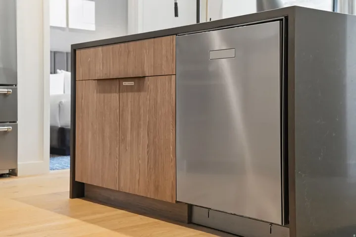 Integrated dishwasher and custom cabinetry at the end of the quartz kitchen island.