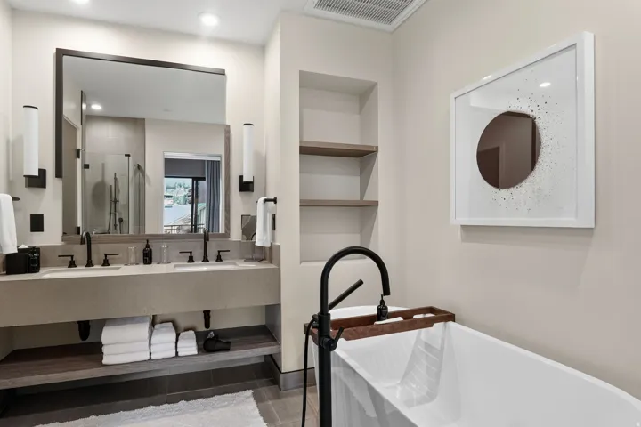 Primary bath with a double vanity, freestanding soaking tub and matte black fixtures, the case for a slow morning.