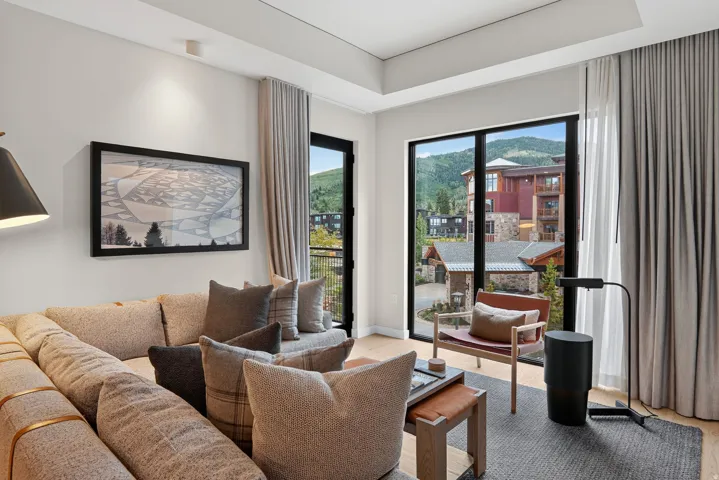 Great room of this ski-in, ski-out Park City residence, with sectional seating and windows framing Canyons Village.