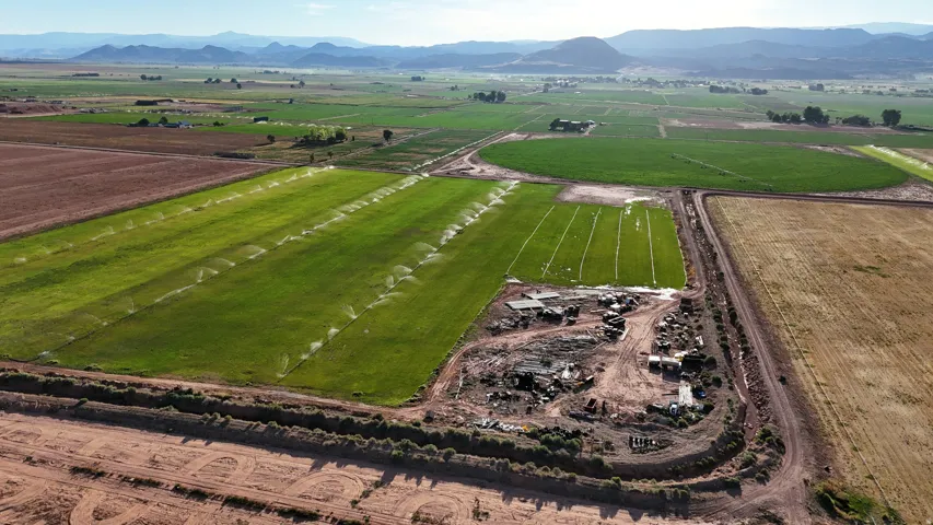 Expansive agricultural land featuring irrigated fields, cultivated areas, and distant mountainous terrain