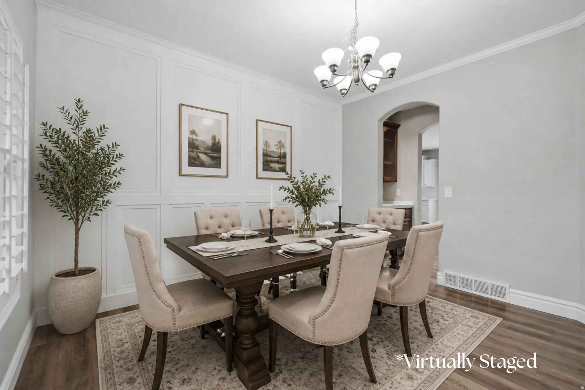 Crown molding, wainscoting, wood-finish flooring, and an arched doorway