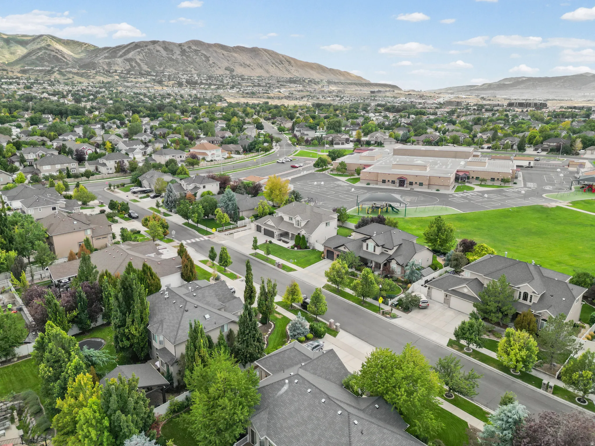 Residential neighborhood featuring a community park, playground, and paved streets with sidewalks