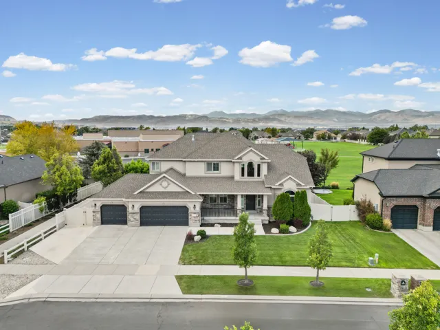 Expansive two-story residence with a three-car garage, concrete driveway, and a manicured front lawn