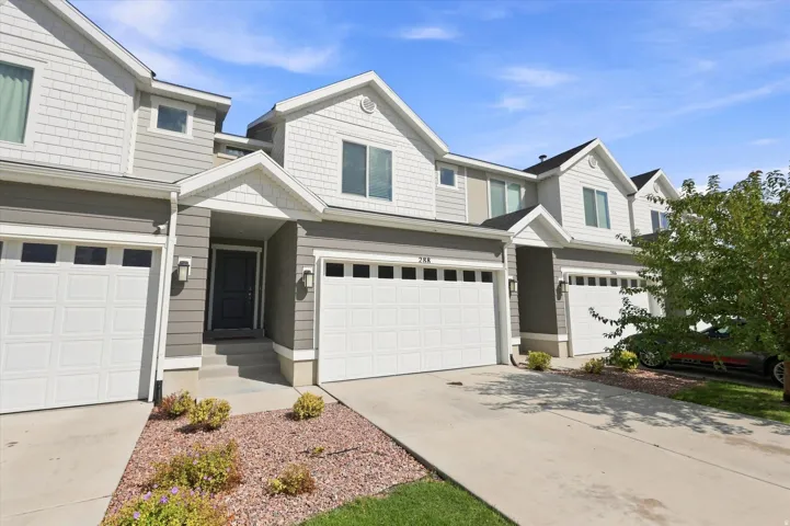 Townhome exterior featuring gray horizontal siding and white shake siding accents