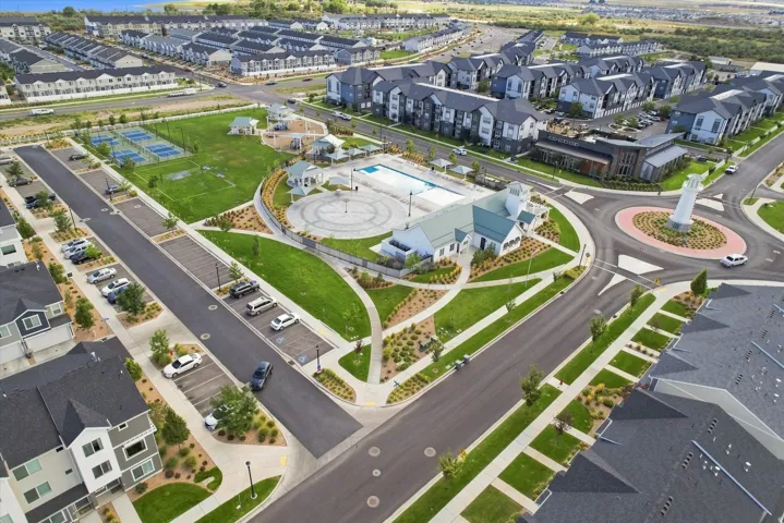 Community layout featuring a central roundabout, recreational building, large pool, and tennis courts