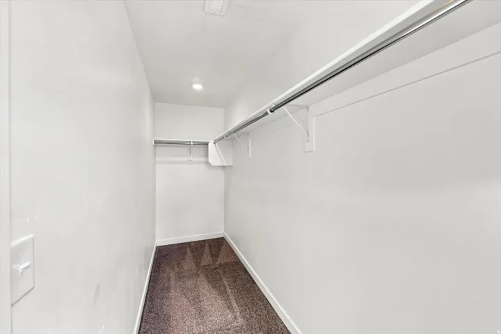 Recessed ceiling lighting, durable carpeting, and white painted walls