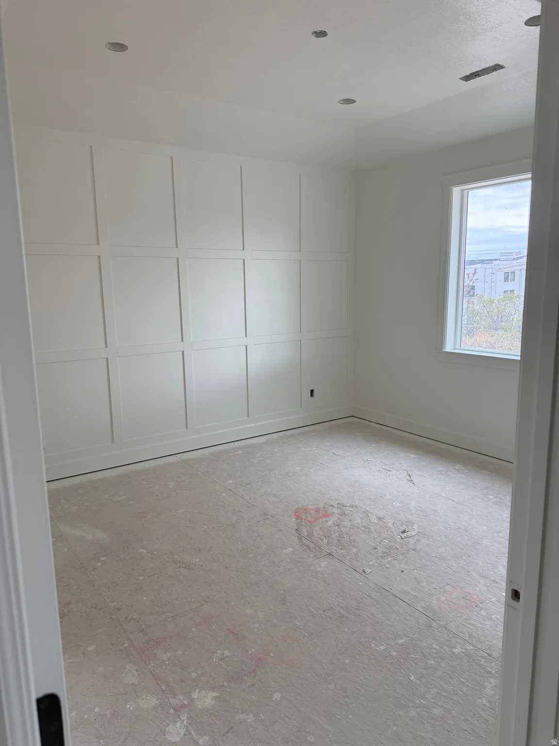 Master Bedroom, White paneled accent wall, recessed ceiling lighting, single window, and white trim