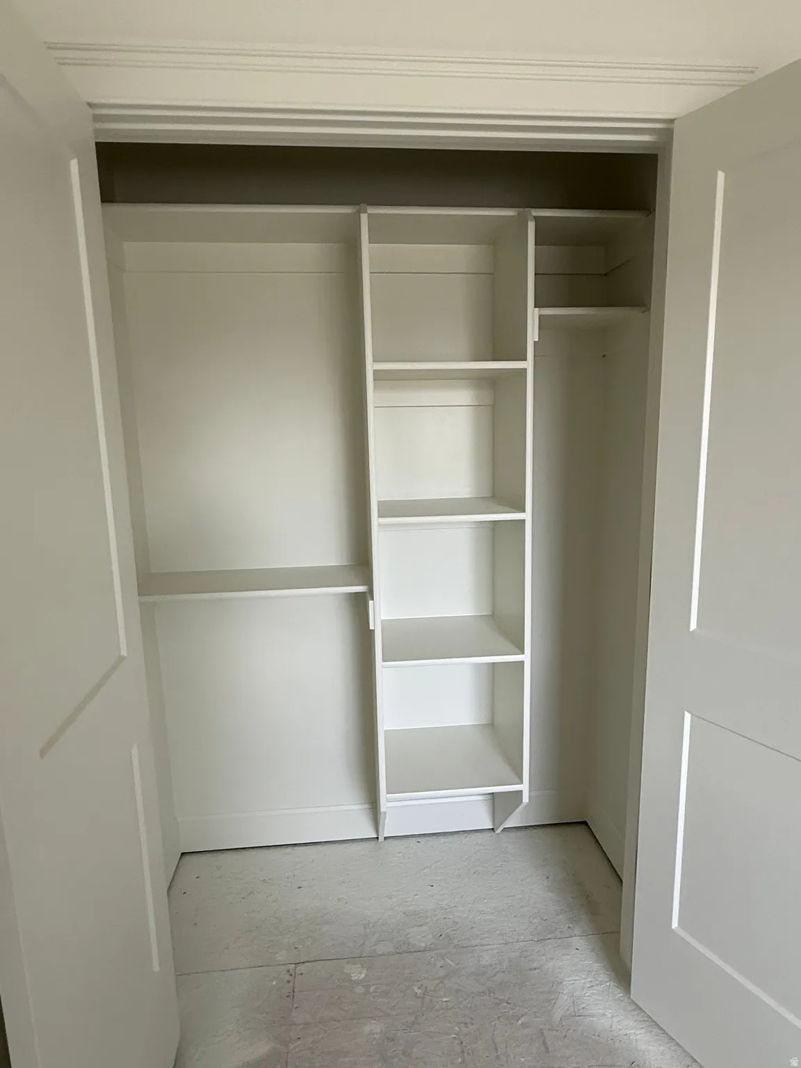 Custom built-in shelving and hanging rods within the closet