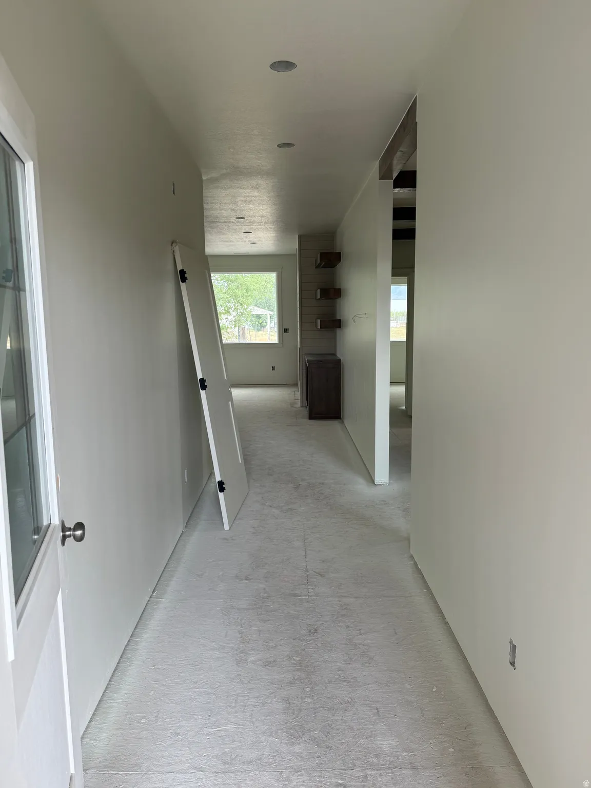 Recessed ceiling lighting, built-in shelving, and a window providing natural illumination