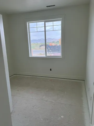 Interior room featuring a large window with grid pattern, white trim, and light-colored walls