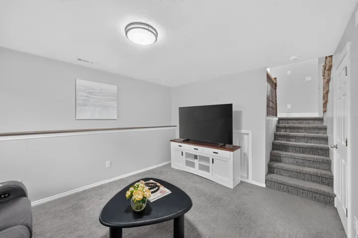 Recessed lighting, light gray wall paint, carpeting, white baseboards, and a white paneled door