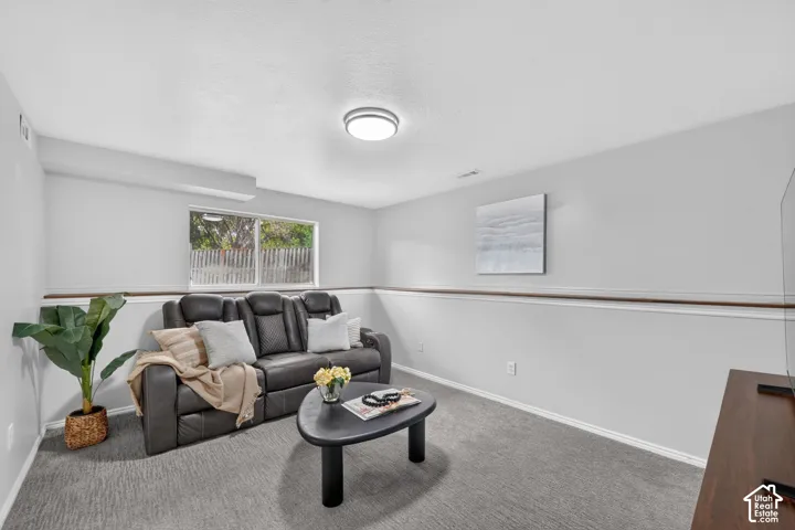 Recessed ceiling light, neutral wall colors, wood-finish chair rail, and wall-to-wall carpeting