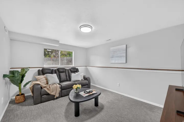 Recessed ceiling light, neutral wall colors, wood-finish chair rail, and wall-to-wall carpeting