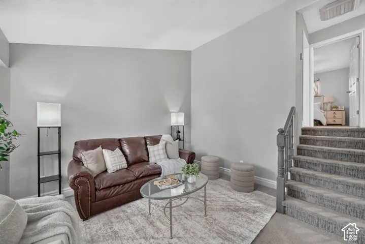 Carpeted staircase with painted handrail