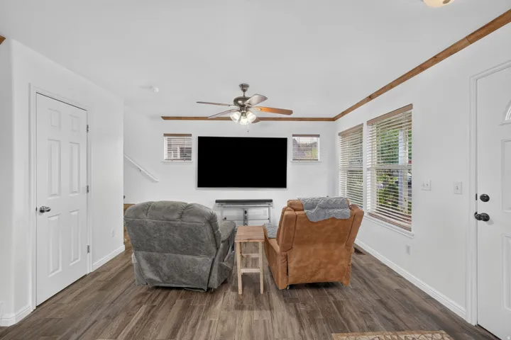 Recessed lighting, wood-finish flooring, white paneled doors, ceiling fan with integrated lighting, and multiple windows with blinds