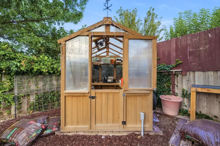 Wood-frame greenhouse with translucent roof and side panels