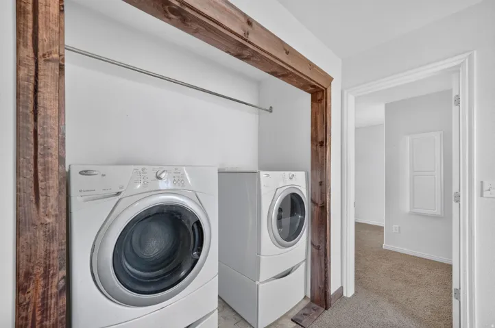 Dedicated laundry area featuring a wood-finish frame and a built-in hanging rod