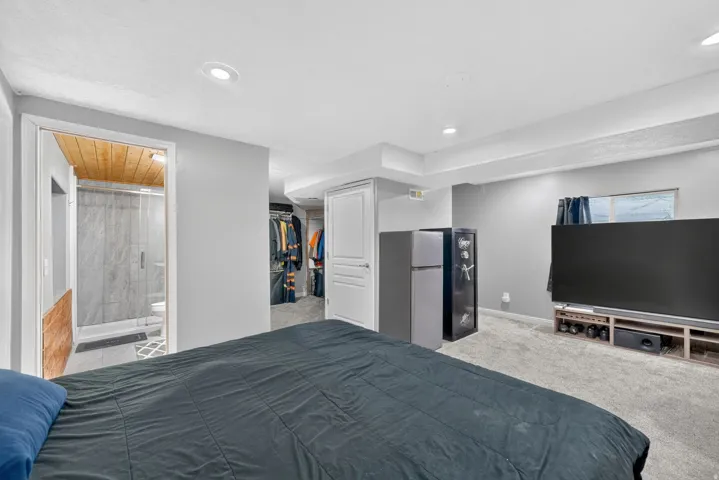 Recessed lighting, wood-finish ceiling in bathroom, glass-enclosed shower, built-in shelving in closet, light gray wall paint