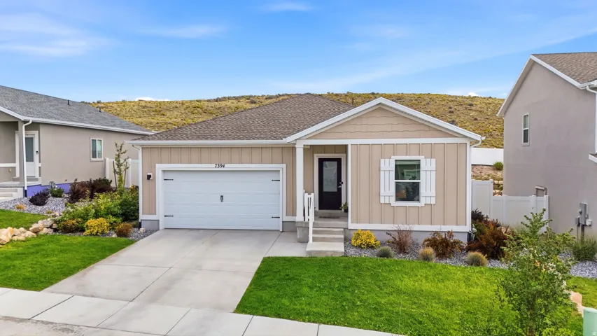 Single-story residence featuring a two-car garage, front porch with steps, and a decorative white shutter accent window