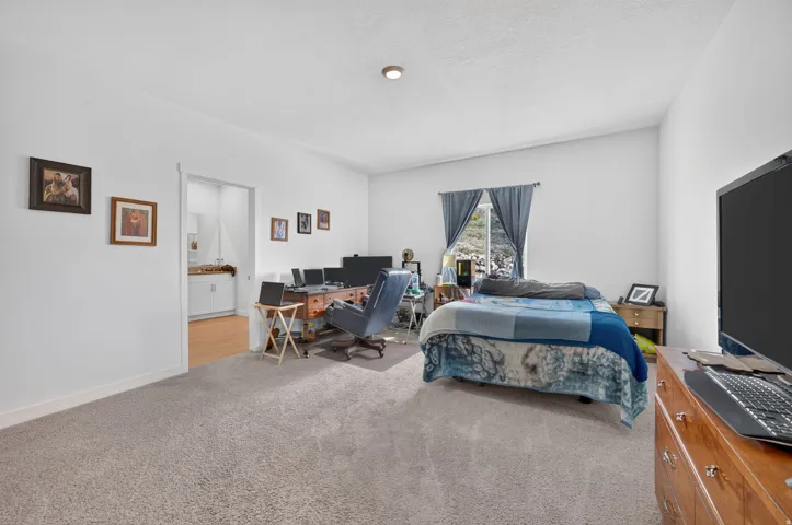 Carpeted flooring, white painted walls, recessed ceiling light, window with exterior scenery, and wood-finish flooring in the opening