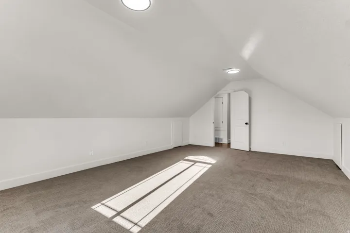 Sloped ceilings, recessed lighting, white interior doors, and gray carpeting