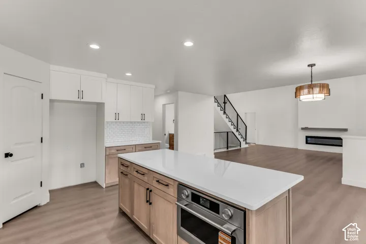 Contemporary kitchen featuring white shaker upper cabinetry and natural wood-finish lower cabinetry