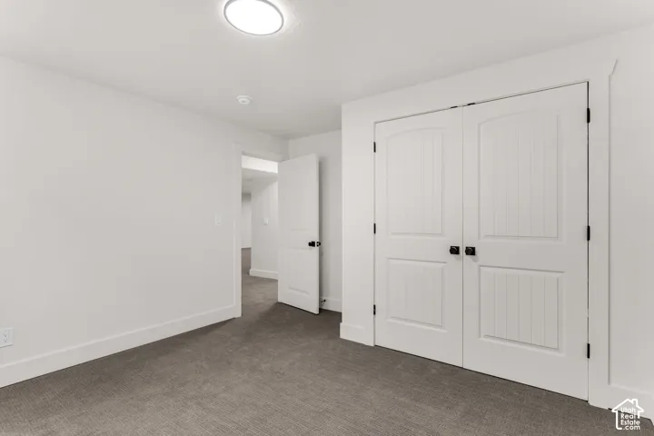 Neutral wall paint, carpet flooring, recessed ceiling light, paneled double doors with dark hardware, and white trim