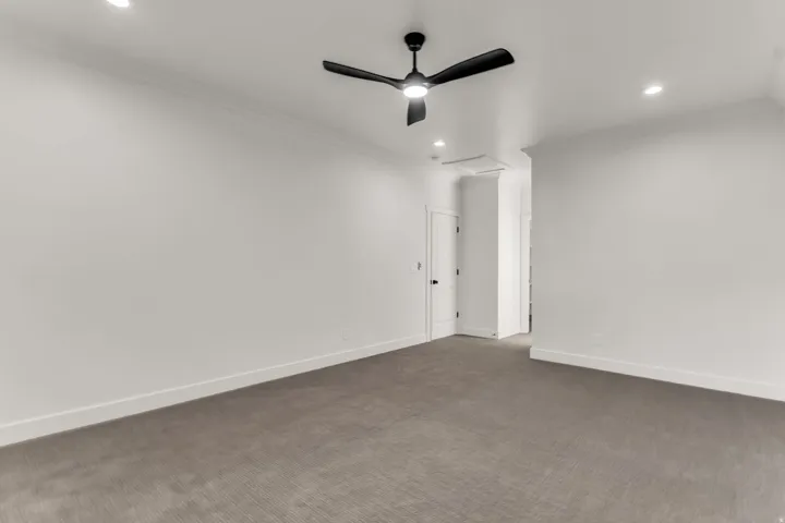 Recessed lighting, crown molding, ceiling fan with integrated light, and neutral wall finishes