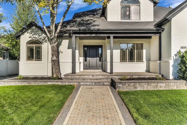 Modern farmhouse residence featuring a symmetrical facade with white exterior cladding, black-trimmed windows, and a covered front portico