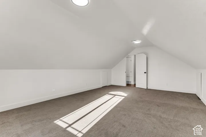 Sloped ceilings, recessed lighting, white interior doors, and gray carpeting