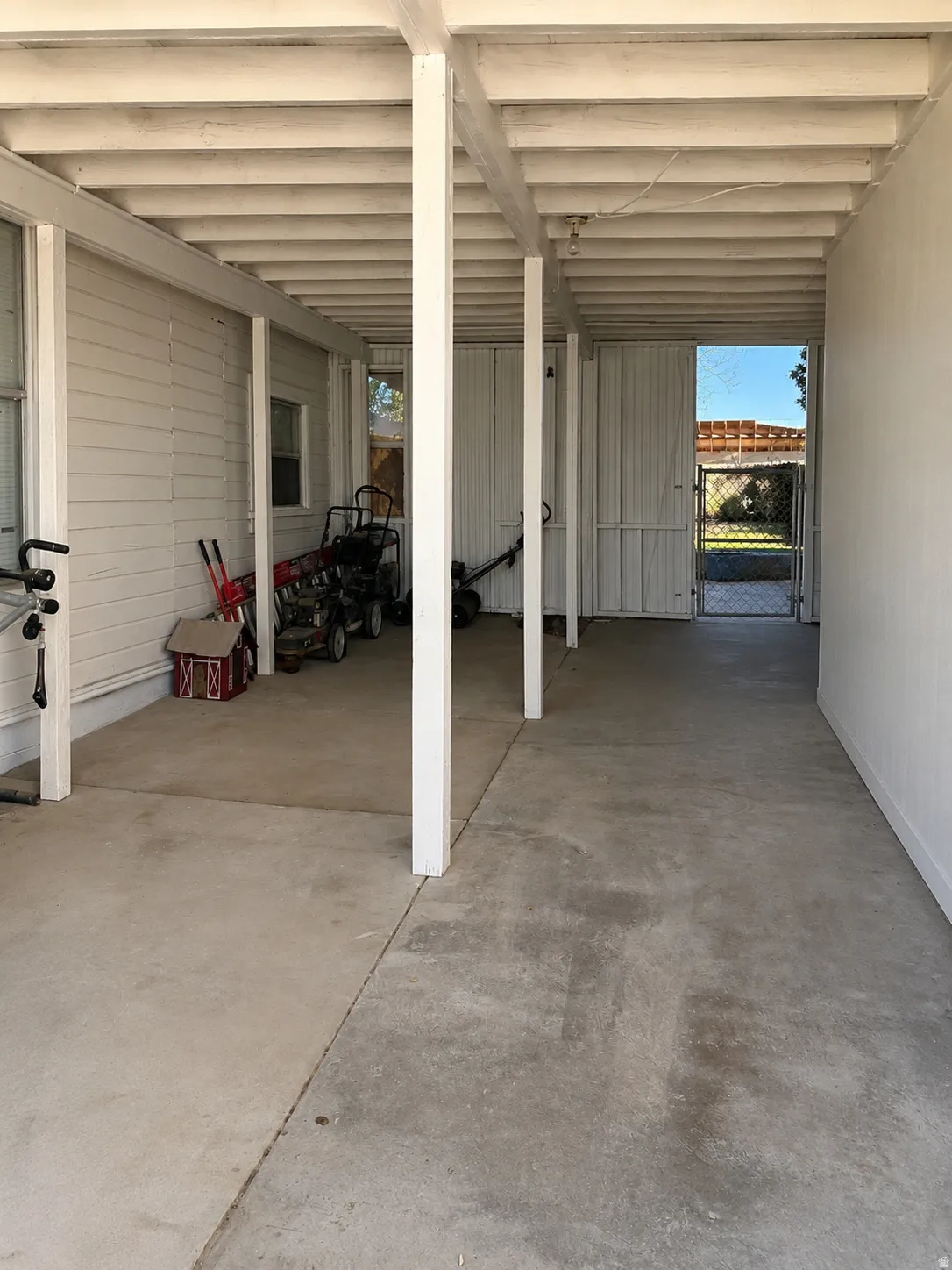 Covered patio with exposed beam ceiling, concrete flooring, and direct exterior access