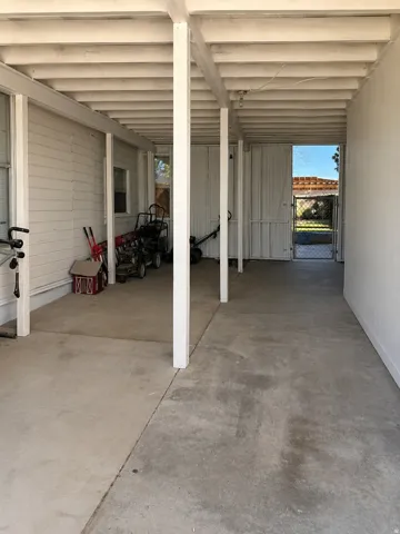 Covered patio with exposed beam ceiling, concrete flooring, and direct exterior access