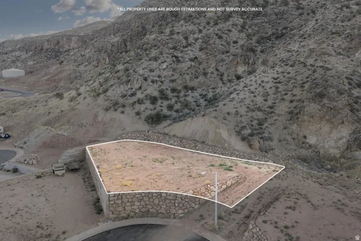 Property bordered by stone retaining walls, with a natural desert landscape