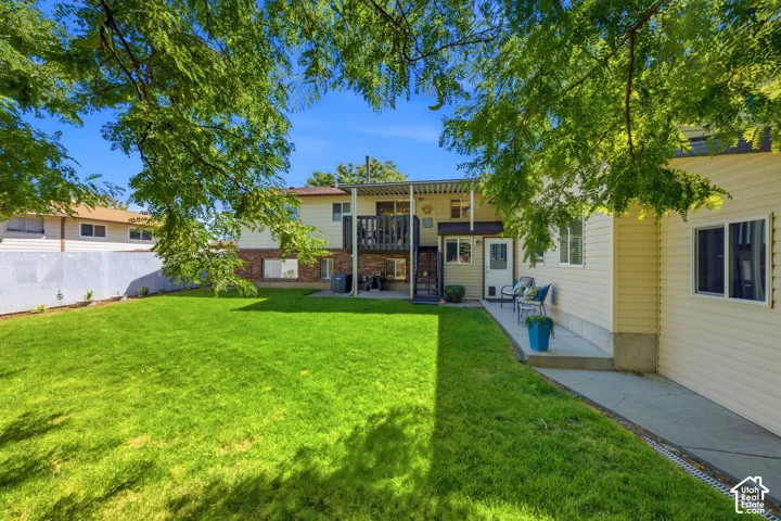 View of the large shaded, fully fenced backyard with mature trees as well as a view of the flex space and the attached storage space behind it.
