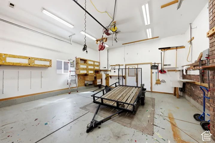 Oversized garage with 10' tall garage doors and double swinging doors that lead into the attached back flex space and basement entrance.
