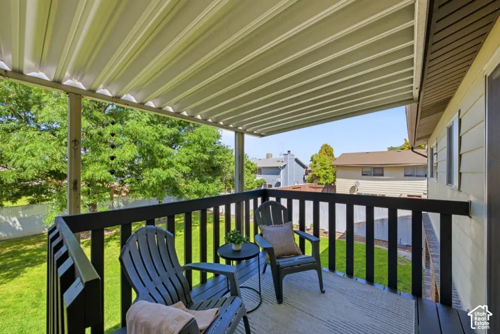 Covered back deck off the upstairs kitchen with access down to the yard
