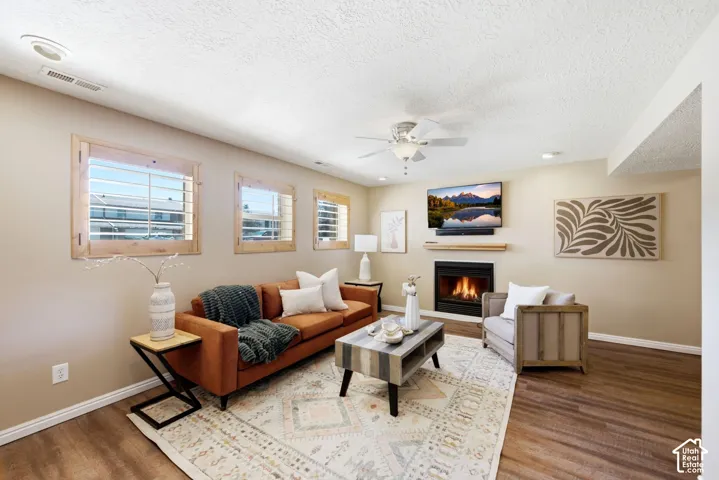 Basement living room with LVP flooring, above-ground windows, and a fireplace