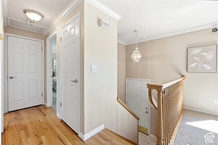 View of the split entry and hallway leading to the upstairs bathroom and two bedrooms. Real hardwood flooring.