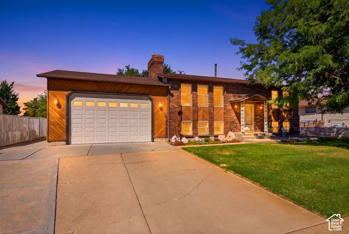 Front view of the home with an extra-large driveway, extra parking, 10' tall garage doors, an extra-height garage, a shaded front patio, and a fully fenced backyard with multiple gates for access.