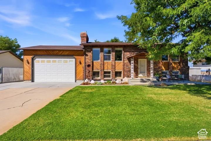 Front view of the home.  Large driveway with extra parking, a fully fenced backyard, a nice shaded front patio, and a large, oversized garage with extra height and 10' tall garage doors.