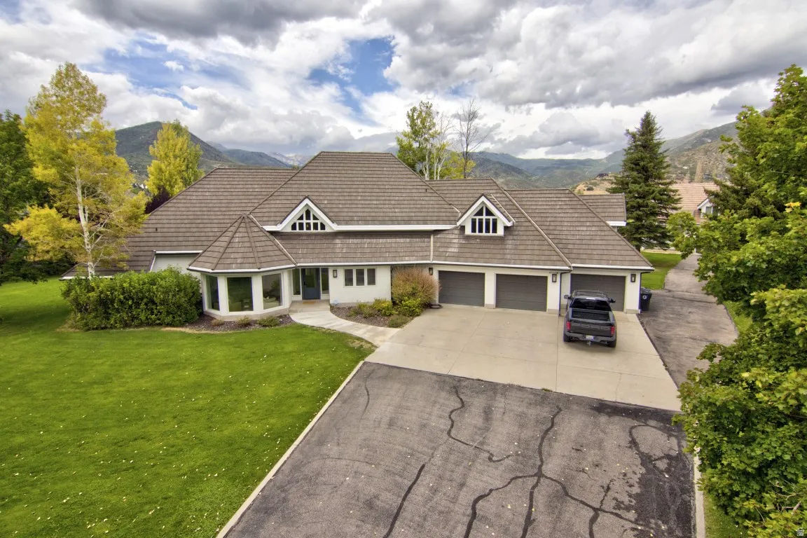 Expansive property featuring a multi-gabled roofline, three-car garage, and a large front lawn