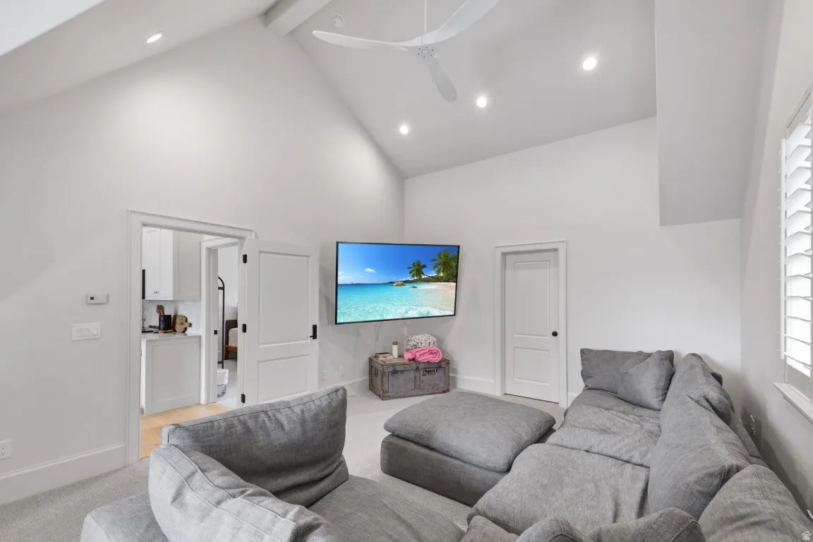 Vaulted ceiling with a ceiling fan, recessed lighting, white double doors, and a window with plantation shutters