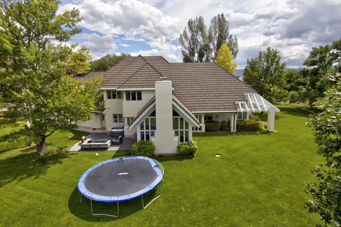 Expansive lawn with mature trees and a structured patio area