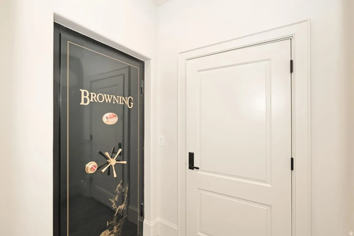 Wall-mounted Browning safe with a gold-toned handle and a white paneled door with a matte black lever handle
