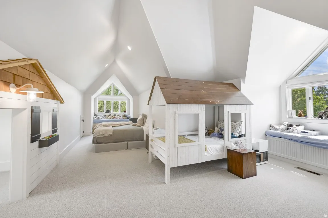 Vaulted white ceilings, recessed lighting, expansive window seating, and a large triangular window